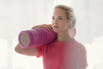 Naklejka premium Portrait of beautiful fitness woman holding foam roller