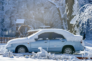 Parked car in the city street covered with winter snow