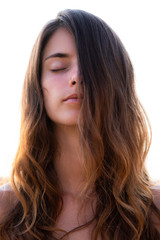 Portrait of a young pretty woman with closed eyes and long wavy hair partially covering her face