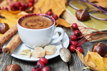 Hot steaming cup with coffee. Autumn fall leaves.
