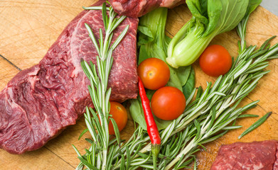 Raw marbled beef with vegetables on a cutting board