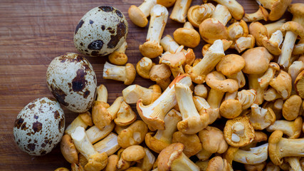 Wild forest mushrooms chanterelles lie on a peeled board