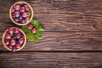 Ripe grapes in bowl on wooden table. Top view. Free space for text. - 227123968