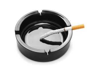 Cigarette in black ashtray isolated on white background