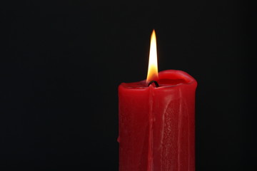 Candle on dark background.