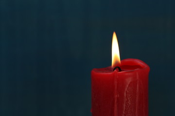 Red candle on blue background.