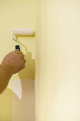 Hand applying paint on wall
