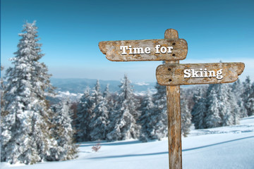 Time for skiing. Information sign and blurred background.