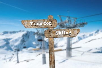 Time for skiing. Information sign and blurred background.