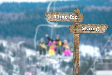 Time for skiing. Information sign and blurred background.