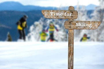 Time for skiing. Information sign and blurred background.