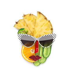 Tasty art / Creative concept photo of cubist style female face in sunglasses made of fruits and vegetables, on white background.
