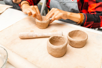 Young woman create clay and ceramic art dishes in pottery workshop