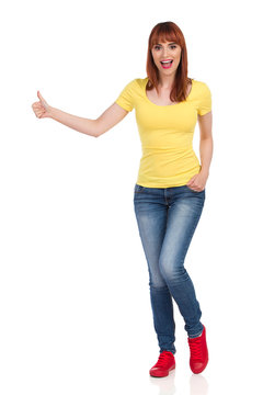 Excited Casual Young Woman Is Looking At Camera, Showing Thumb Up And Shouting