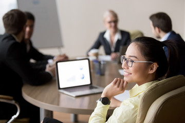 Back view of smiling Asian female employee distracted form office meeting looking in window...