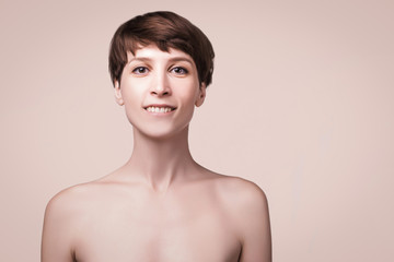 Obraz premium Beautiful woman. Female face close up. Portrait of young caucasian woman at studio isolated on pastel. Fresh skin and beauty concept. Short haircut, long neck, perfect skin