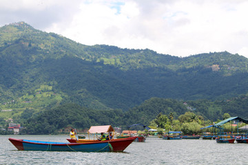 Fototapeta na wymiar Boats around Phewa Lake and hills in Pokhara, a popular tourist destination