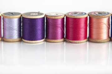 Colorful spools of thread on a white background