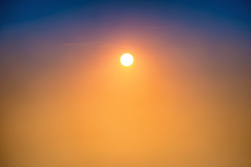 Sunset in the sky with big sun, blue, orange and red dramatic colors
