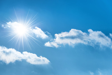 Naklejka na ściany i meble Sun with sun rays on the blue sky with clouds