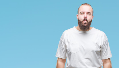 Young caucasian hipster man wearing casual t-shirt over isolated background making fish face with lips, crazy and comical gesture. Funny expression.