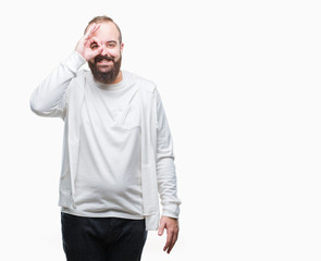 Fototapeta premium Young caucasian hipster man wearing sport clothes over isolated background doing ok gesture with hand smiling, eye looking through fingers with happy face.