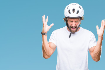 Handsome hispanic cyclist man wearing safety helmet over isolated background celebrating mad and crazy for success with arms raised and closed eyes screaming excited. Winner concept