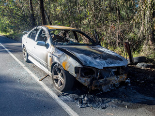Abandoned burnt out car at the road side front image