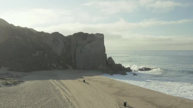 Aerial pullback of a cliff on the beach.