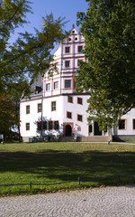 Fototapeta na wymiar Ponitz / Germany: Renovated Renaissance manor house with Neo-Gothic portal on a sunny day in October