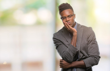 Young african american business man over isolated background thinking looking tired and bored with depression problems with crossed arms.