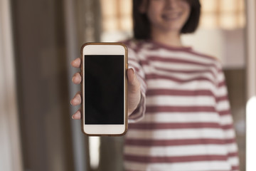 Girl is showing a blank phone screen mock up.