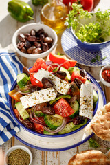 Greek salad. Traditional Greek salad consisting of fresh vegetables such as tomatoes, cucumbers, peppers, onions, oregano and olive oil, top viewl. A delicious and healthy vegetarian dish