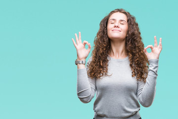 Beautiful brunette curly hair young girl wearing a sweater over isolated background relax and smiling with eyes closed doing meditation gesture with fingers. Yoga concept.