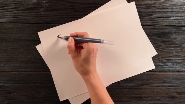hand with penbrush does lettering exercise