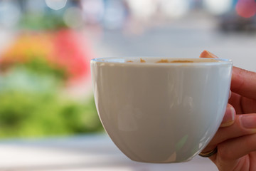 Woman's hand holding small coffee mug