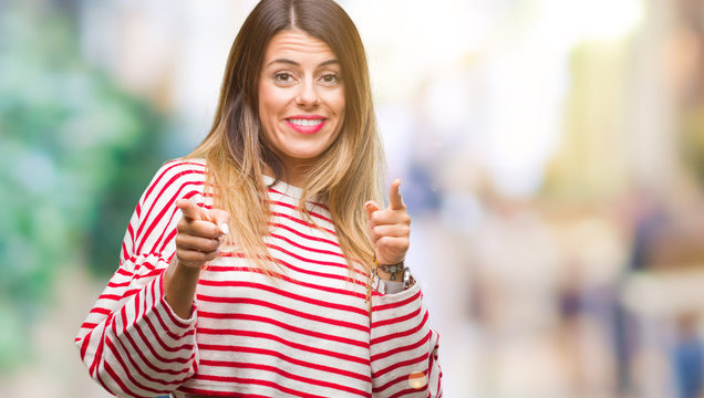 Young beautiful woman casual stripes winter sweater over isolated background pointing fingers to camera with happy and funny face. Good energy and vibes.