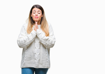 Young beautiful woman casual white sweater over isolated background begging and praying with hands together with hope expression on face very emotional and worried. Asking for forgiveness