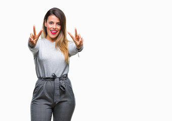 Obraz premium Young beautiful worker business woman over isolated background smiling looking to the camera showing fingers doing victory sign. Number two.