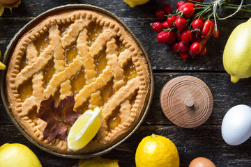 Delicious lemon pie with cooking ingredients on the wooden table 