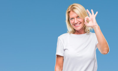Fototapeta premium Middle age blonde woman over isolated background smiling positive doing ok sign with hand and fingers. Successful expression.