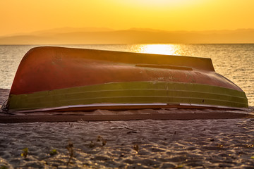 Naklejka premium boat on the shore with sunrise