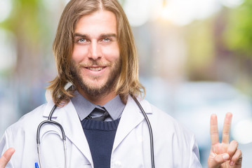 Young handsome doctor man with long hair over isolated background showing and pointing up with...
