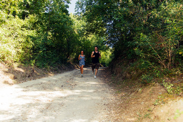 Obraz premium Athletic couple running together on forest trail