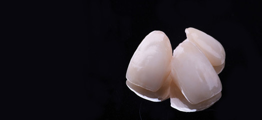 dental ceramic veneers and crowns isolated with mirror background.