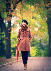 Redhead girl with umbrella in a park. Autumn season