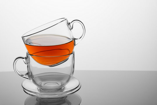 Two tea cups with tea on a white background.