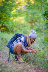 Young woman walking alone in the woods. Hiking concept in the mountain in summer