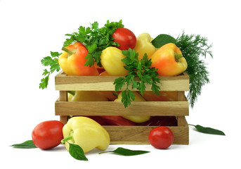 Sweet peppers, tomatoes and fresh herbs in a wooden box. Isolated. Delivery. Sale of vegetables and spices. Isolated on white. Concept.