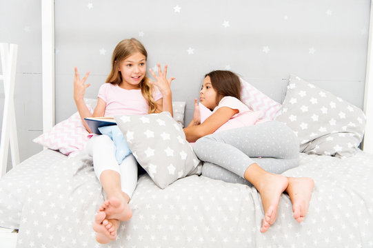 Children read book in bed. Reading before bed can help sleep better at night. Stories every kid should read. Family tradition. Girls best friends read fairy tale before sleep. Best books for kids - Powered by Adobe